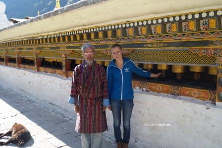Susanne Huber und ein Bhutaner an den kleinen Gebetsmuehlen des Chorten Kora